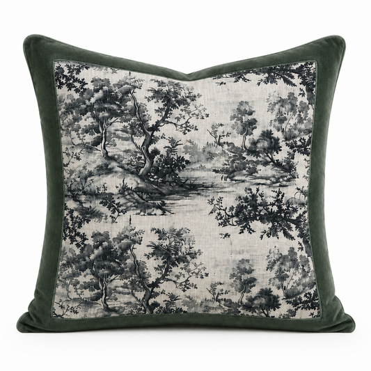 A square throw pillow featuring a dark green velvet border and a central toile-style landscape print in black and gray on a light beige linen background, shown against a plain white studio backdrop.